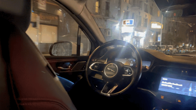 Animated GIF taken from inside a self-driving Waymo Jaguar driving through a city, no one in the driver's seat